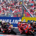 Ilustrasi rombongan pembalap MotoGP saat melaju di tikungan dalam sesi balapan.