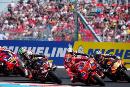 Ilustrasi rombongan pembalap MotoGP saat melaju di tikungan dalam sesi balapan.