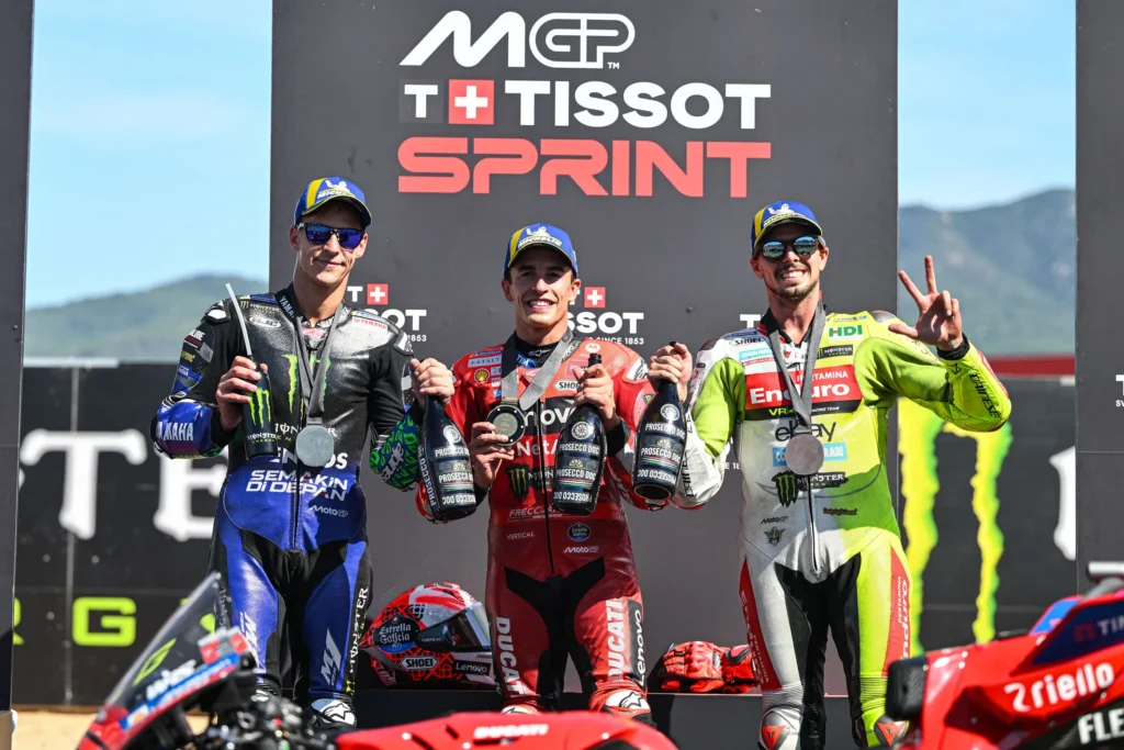 Tiga pembalap MotoGP berdiri di podium Sprint Race setelah finis di posisi teratas.