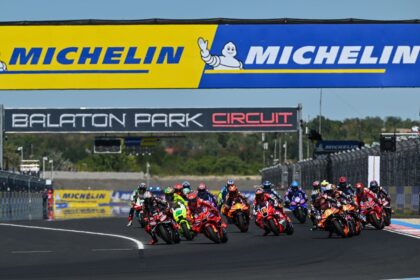 Rombongan pembalap MotoGP melaju di Sirkuit Balaton Park pada MotoGP Hungaria dengan papan Michelin di atas lintasan.