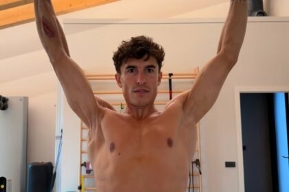 Marc Marquez mengangkat kedua lengannya saat berlatih, memperlihatkan kondisi bahu dan lengan kanannya setelah tujuh operasi