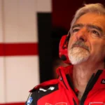 Gigi Dall’Igna mengenakan seragam Ducati dan headset merah di garasi tim.