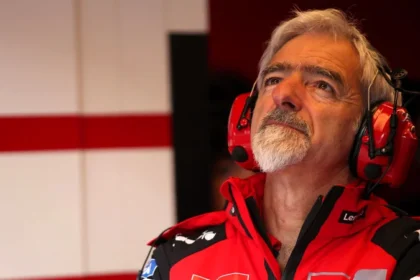 Gigi Dall’Igna mengenakan seragam Ducati dan headset merah di garasi tim.