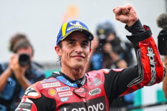 Marc Marquez mengangkat tinju sambil mengenakan topi Michelin dan baju balap Ducati usai Sprint Sepang.