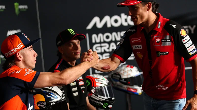 Pedro Acosta berseragam KTM bersalaman dengan Marc Marquez yang mengenakan seragam Ducati.