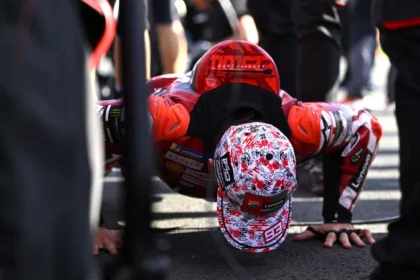 Marc Marquez melakukan push-up di grid Motegi dengan mengenakan helm dan baju balap Ducati.