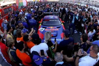 Mobil balap nomor 3 berlivery Red Bull dan Verstappen Racing dikelilingi penggemar di grid.