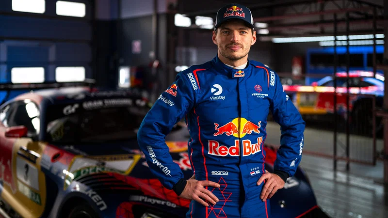 Max Verstappen mengenakan baju balap biru dengan logo Red Bull di depan mobil balap GT.