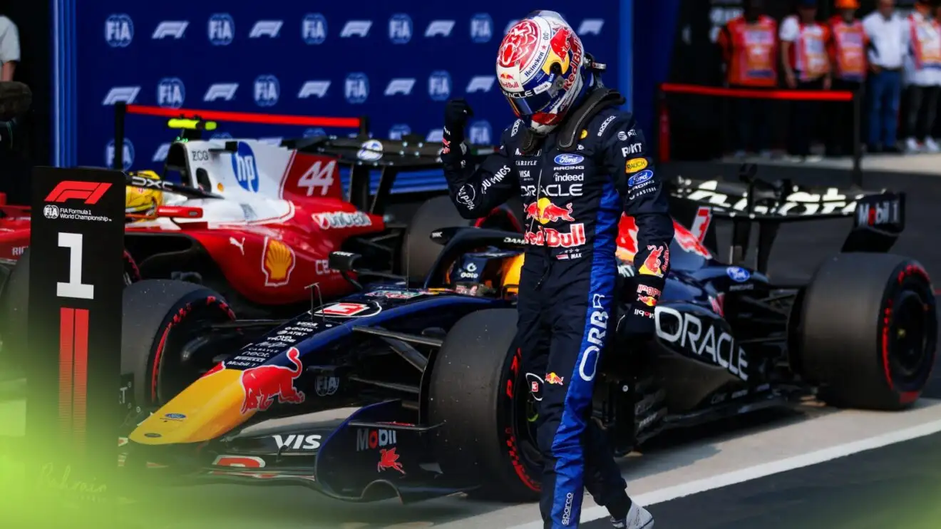 Max Verstappen mengangkat kepalan tangan di samping mobil Red Bull setelah meraih pole di Sepang