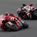 Marc Marquez di atas Ducati diikuti Jorge Martin dengan Aprilia di tikungan