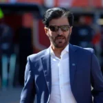 Presiden FIA Mohammed Ben Sulayem mengenakan jas biru, kemeja putih, dan kacamata hitam.